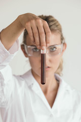 Scientist, nurse or doctor inspecting a blood vial