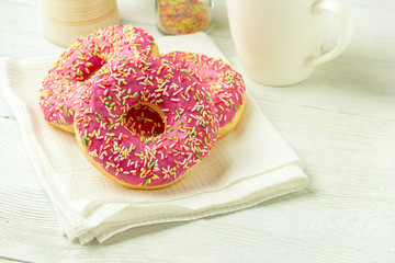 Donut on a kitchen towel and on a wooden table. Photo of sweets.