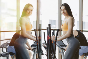 young attractive girl at gym on exercise bike, fitness and yoga