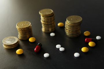 Pills and capsules stacks of coins. The concept of costly treatment, health close-up