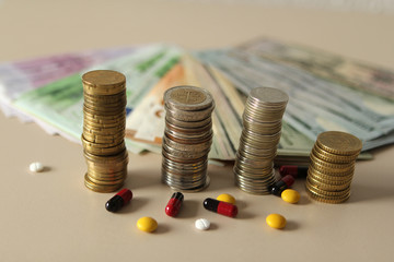 Closeup of silver and copper coins and banknotes of all states on a light background and pills with pills