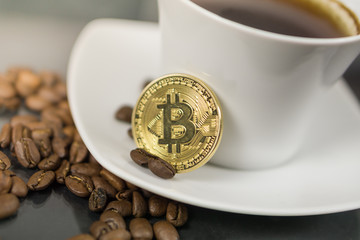 Bitcoin cryptocurrency coin with coffee cup and coffee beans