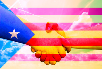 Gesture made by the flag with colored hands showing friendship and greeting with two male hands shaking hands, on a blue sky background