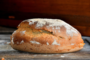 Homemade rustic bread on a wooden background.