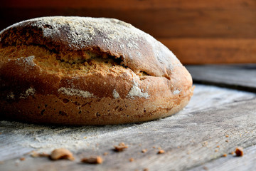 Homemade rustic bread on a wooden background.