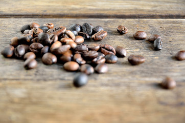 Roasted coffee grains on wooden boards.