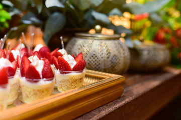 dessert with cream and strawberry, strawberry desserts on a tiered stand, elegant birthday party dessert table, delicious sweet treats, luxurious event sweets