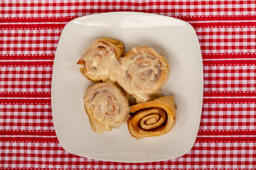 A Plate of Homemade Cinnamon Rolls on a Red Checkered Cloth