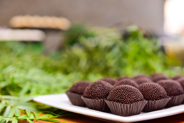 brigadeiros on white tray and green background, brazilian sweet, chocolate candy, party candy, chocolate truffles, brigadeiro, chocolate sprinkles, chocolate candy, sweets table