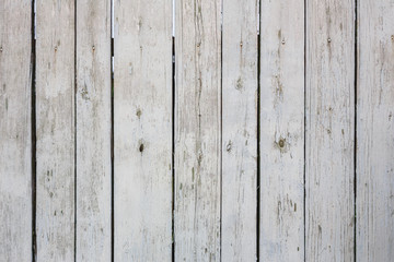 The texture of the old shabby fence of painted white paint boards