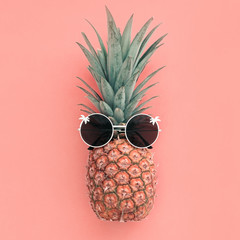 Pineapple fruit in sunglasses on pink pastel background