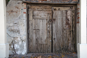 weathered wood closed house doors with rusty lock