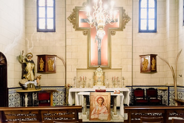 Valencia, Spain - March 30, 2019: Interior of a chapel of a Catholic church with a portrait of Jesus and crucifix on the altar.