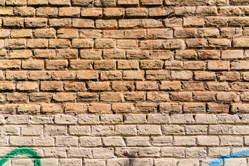 Texture of a brick wall painted in orange tones, ideal for background with space for free text.