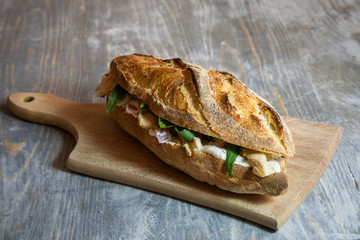 Brie sandwich in a French baguette, made of Brie de Meaux Cheese with some slices of rucola salad...