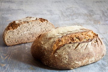 Two loafs (or miche) of French sourdough, called as well as Pain de campagne, on display on a wooden table. Pain de Campagne is a typical French huge loaf of bread abiding by the traditional codes