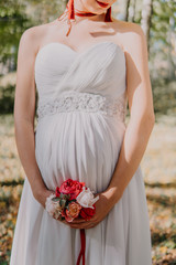 Fototapeta na wymiar pregnant woman in white dress with flowers
