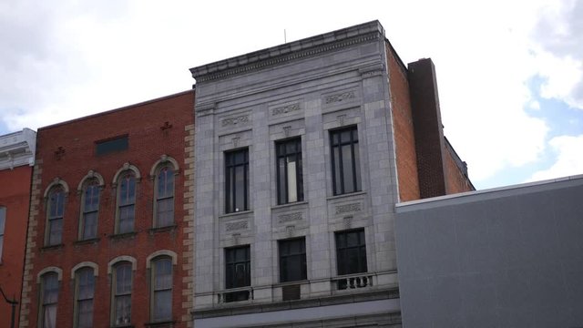 Establishing shot of gray second story small business building in american town