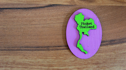 Souvenir or fridge magnet from Thailand on wooden background © arfa_adam