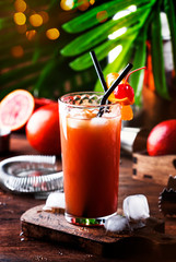 Summer refreshing low alcoholic cocktail with vodka, orange juice, bloody orange and ice cubes. Wooden table. Selective focus. Copy space