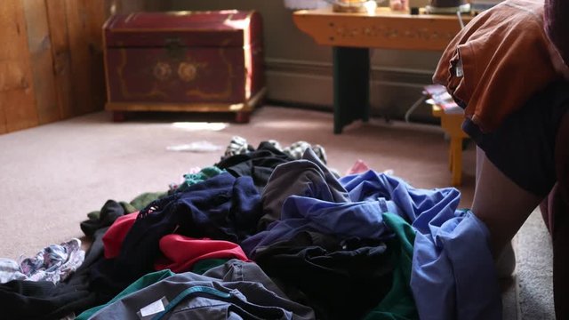 Middle-aged Woman folding laundry in living room - shot 1 of 3