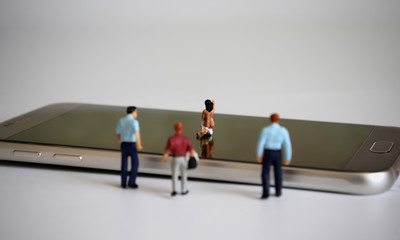 Smartphone and miniature people. The concept of illegal video leakage.