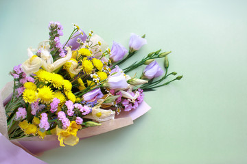 Spring flowers on pastel green background