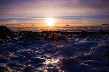 Sunset in icy landscape with illuminated ice formations