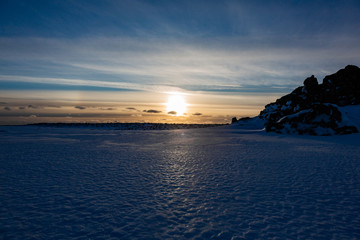 Fototapeta na wymiar Sunset over the ice and snow in a cold winter landscape