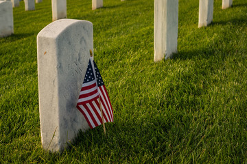American flag by a grave marker of a soldier. Can be used for Memorial Day or Independence Day,...