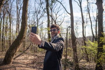 one young man, hilariously smiling while making a selfie on his phone.