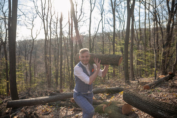one young man, dressed in suit, carrying wood log on his shoulder.