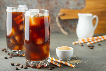 Ice coffee in a tall glass with cream.