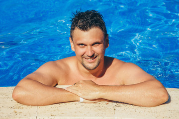 tanned man on vacation swimming in the pool