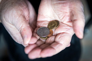 Coins in the hands of a pensioner. concept of poverty and destitution.