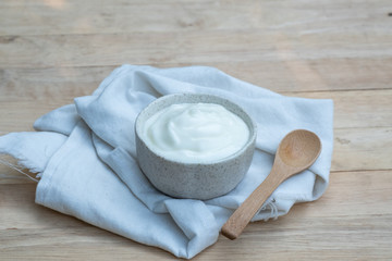 Fototapeta na wymiar Natural homemade plain organic yogurt in ceramic bowl on wood texture background