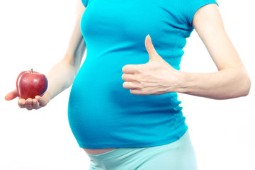 Woman in pregnant holding fresh apple and showing thumbs up, healthy nutrition during pregnancy