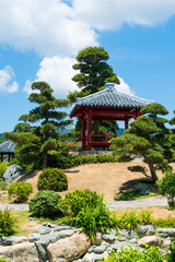 Fototapeta na wymiar japanese style garden with pagoda and trees, vertical shot