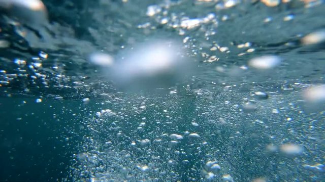 Underwater Bubbles with sunlight through water surface, natural slow motion underwater scene