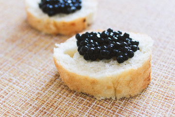 Top view of Tasty Sandwich with black caviar on White marble background.  .Free space for text. Black caviar. Luxurious culinary delicacy.