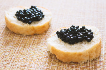 Top view of Tasty Sandwich with black caviar on White marble background.  .Free space for text. Black caviar. Luxurious culinary delicacy.