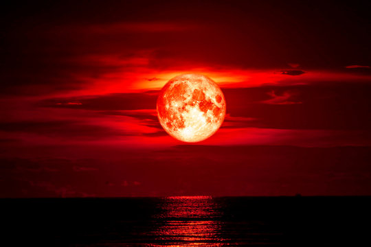 full blood moon on sea and ocean light sky silhouette cloud