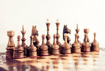 Wooden chess pieces on a chessboard, leadership concept on white background.