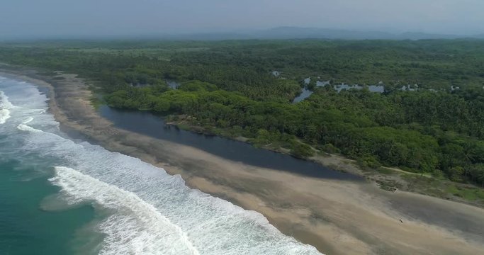 Aerial orbit wide shot of the beach, the lagoon and the mangroves of La Ventanilla, Oaxaca