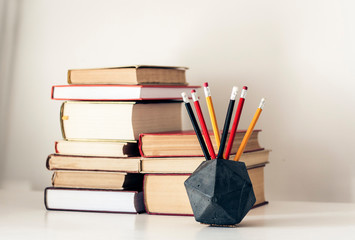 Stack of old books and pencils in office background for education concept.