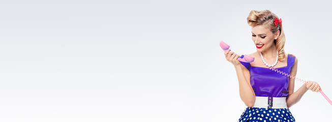 smiling woman with phone, dressed in pin-up style dress