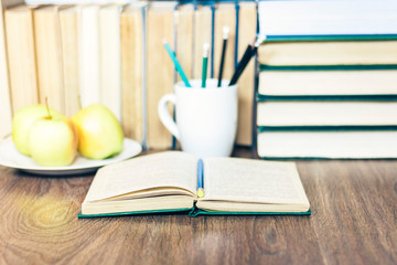 Stack of books, pencils, open book, glasses, background for education learning concept.