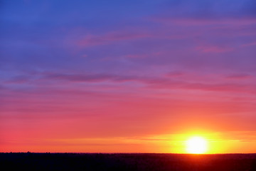 natural color of sky and forest with sunset sun above forest horizon nature background rural scenery landscape on spring time with beautiful sunrise light transition from blue to red and yellow