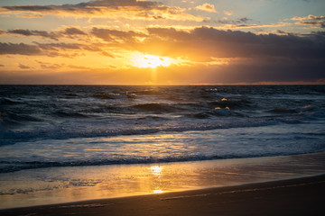 Obraz na płótnie Canvas Colorful beach sunrise with a vibrant sky line 