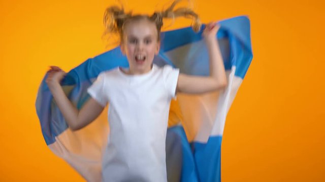 Nice teen girl jumping with argentinian flag cheering for favorite football team